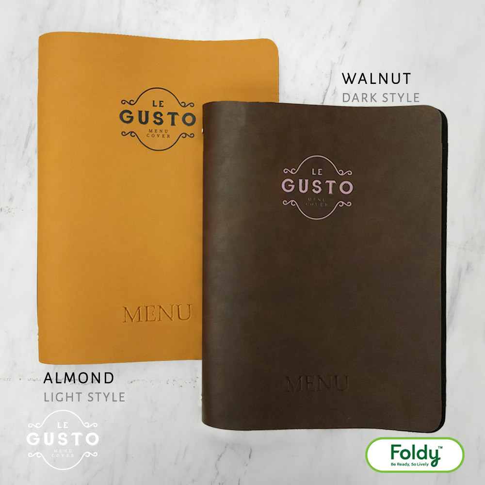 Le-Gusto_Walnut7B2 | แฟ้มเมนู Foldy ( Menu1Folder ) Two leather-style menu covers, mustard Almond Light Style and dark Walnut Style, on a marble surface with Foldy logo in corner.