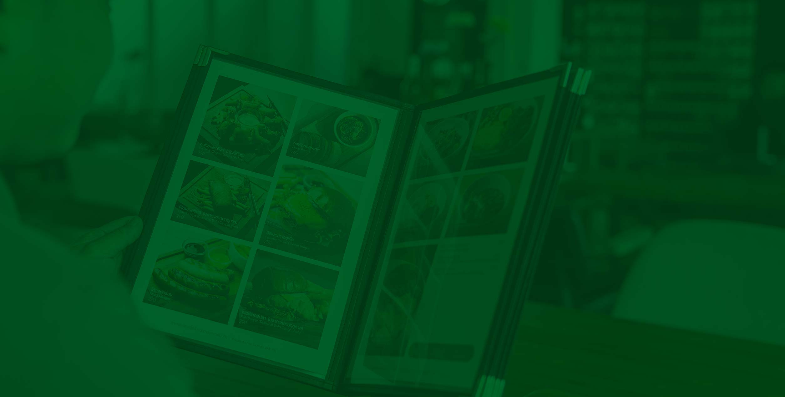 Person holding an open menu with multiple food photos visible on the pages.