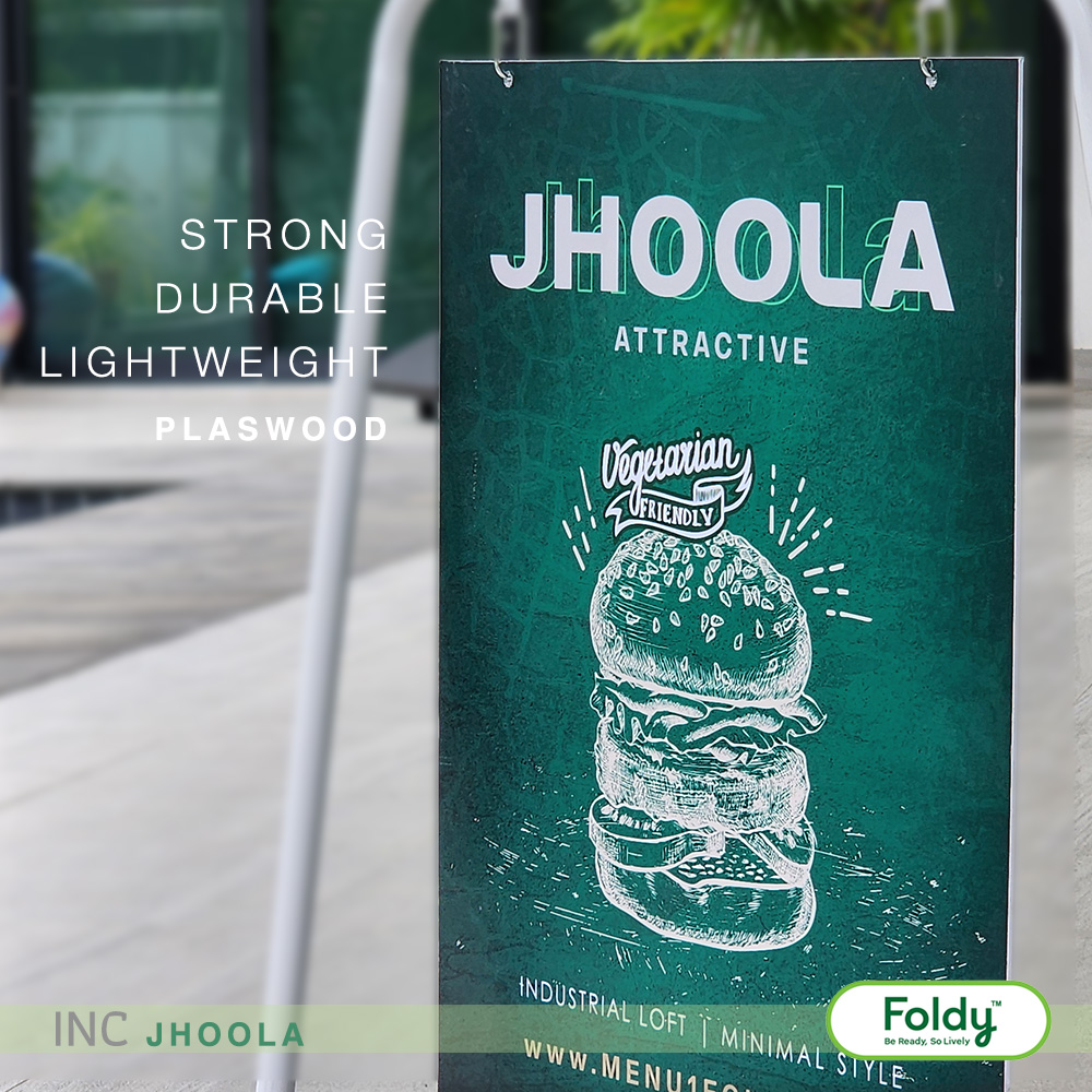 Outdoor green signboard advertising a vegan burger with a hand-drawn illustration and the 'JHOOLA' logo; features a 'Vegetarian Friendly' badge and burger imagery.