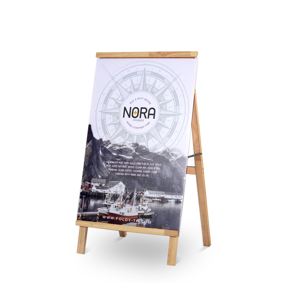 Wooden A-frame sidewalk sign displaying a poster with a compass design and harbor photo promoting NORA