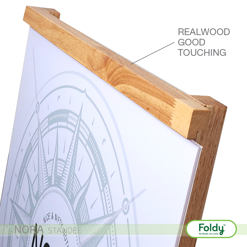 Close-up of a wooden-framed display showing the wood grain on the top edge, with a compass-like print on the panel and the overlay text 'REALWOOD GOOD TOUCHING'.