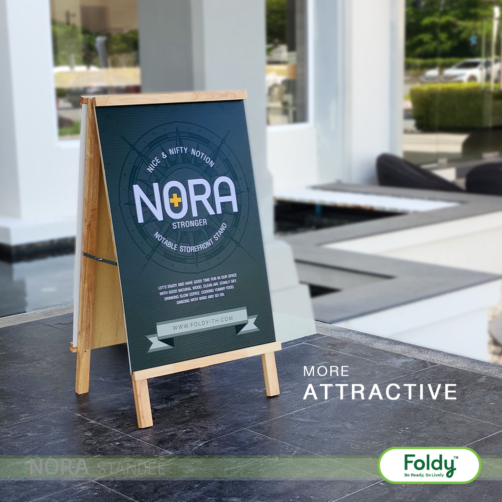 Wooden A-frame chalkboard sign outdoors advertising 'NORA' with 'Stronger' and 'More Attractive' slogans, Foldy logo nearby.